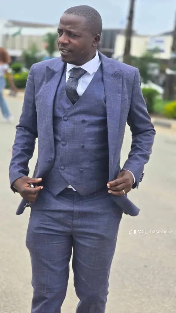 DJ Masomere in navy three-piece suit