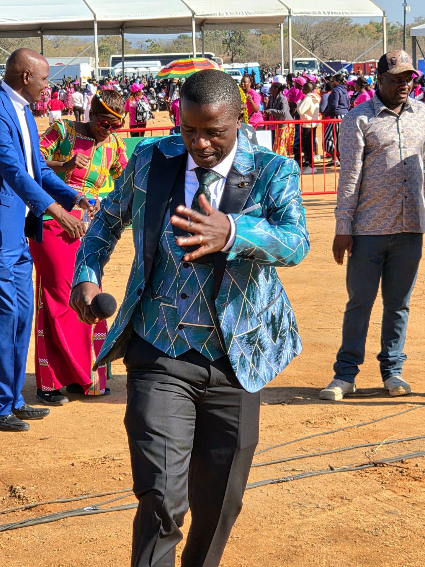 DJ Masomere in teal patterned suit at a national rally